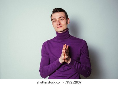 Color Portrait Of A Young Man Wearing Purple Turtleneck Jumper, Looking At The Camera, Against Plain Studio Background