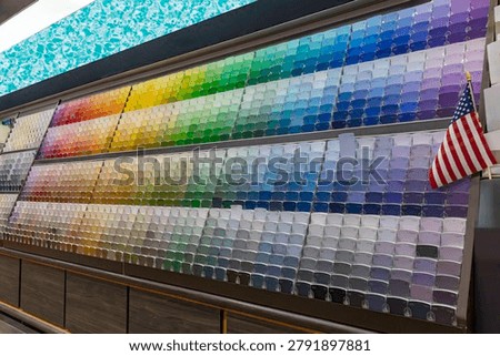 Color sample display wall featuring a wide range of paint swatches organized by shade in a home improvement store.