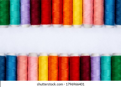 Color sewing threads on white background, top view. Sewing Production. Rows Of Spools Of Thread in Different Colors. Colorful rolls of thread in the textile industry. Banner idea. Thread texture. - Powered by Shutterstock