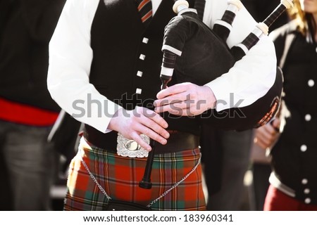 Color shot of a person holding a traditional bagpipe.