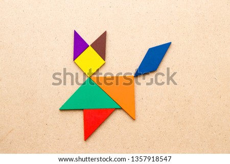 Color tangram puzzle in cat shape on wood background