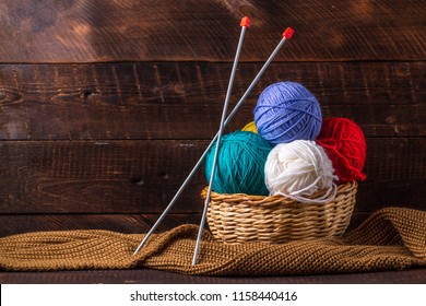 Color thread for knitting, knitted scarf, knitting needles on a dark background. Copy space. Knitting concept