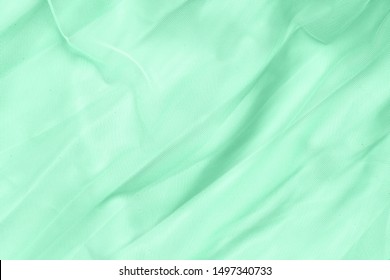 COLOR TREND 2020 Neo mint Tulle fabric background. Seafoam Green Double-layered tulle cloth background. Soft silk fashion background. Green satin fabric texture Stock Photo