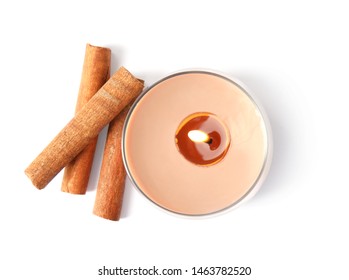 Color Wax Candle In Glass Holder And Cinnamon Sticks Isolated On White, Top View
