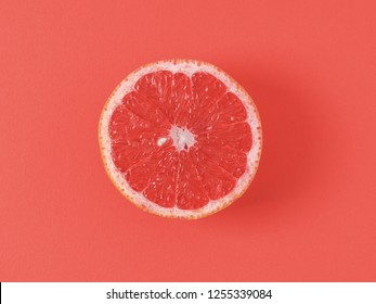 Color of year 2019 Living Coral concept. Grapefruit half on living coral background. Top view or flat lay. Copy space for text.