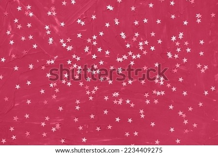 Color of the year 2023 Viva Magenta. Shiny stars on dark red background. Winter abstract background in trendy color. New Year party, Christmas celebration, holidays, dreams concept. Selective focus