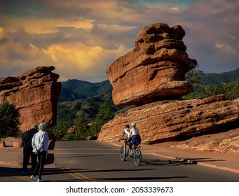 Colorado Springs - 9-19-2021: Two People Ona Two Seat Bicycle Riding Past Balancing Rock At The Garden Of The Gods Near Colorado Springs Colorado