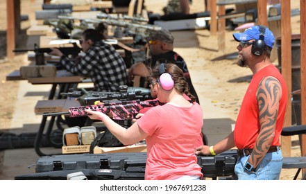 Colorado Springs, CO. USA. April 25, 2021. Unidentified Husband Watching His Wife Shoot Her Pink AR-15 At Dragon Mans Shooting Range. Target Shooting Is A Very Popular Sport. 