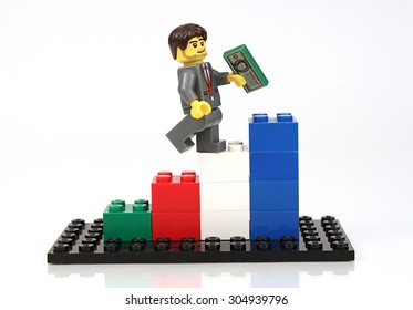 Colorado, USA - August 10, 2015: Studio Shot Of Lego Minifigures Portraying Climbing Business Graph On White Background.