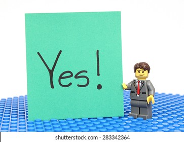 Colorado, USA - June 1, 2015: Studio Shot Of Lego Minifigure With Yes! Sign. Legos Are A Popular Line Of Plastic Construction Toys Manufactured By The Lego Group, A Company Based In Denmark.