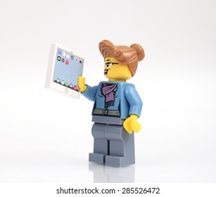 Colorado, USA - June 7 2015: Studio shot of Lego businesswoman with tablet. Legos are a popular line of plastic construction toys manufactured by The Lego Group, a company based in Denmark.