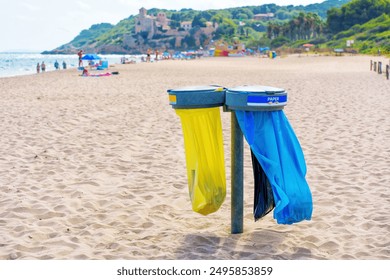 Color-coded trash bins for waste segregation on the Tarragona beach. - Powered by Shutterstock