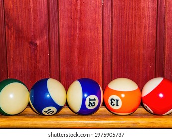 Colored Billiard Balls On A Wooden Shelf. Billiard Ball. Wooden Shelf. Numbered Balls. Gambling. Sports Game. Leisure Activities. Business. Background Image.