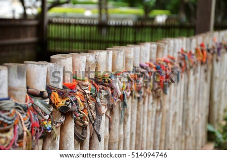 Colored bracelets dedicated to the victims of the killing fields of Choeung Ek in Phnom Penh, Cambodia. Selective focus