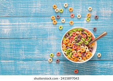 Colored breakfast cereals laid out in a bowl on a blue wooden background, top view, children's healthy breakfast, copy space. - Powered by Shutterstock