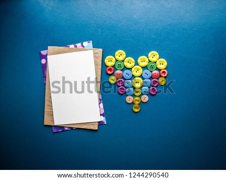 colored buttons and a white envelope on a blue background. postcard layout. St. Valentine's Day