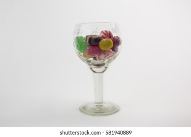 colored caramel sweets in glass vase, isolated on a white background