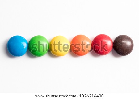 Colored coated chocolate candy similar to m&ms on a white background