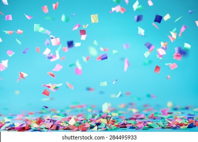 Colored confetti flying on blue background - Shutterstock ID 284495933
