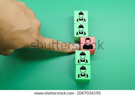 colored cubes with icons of workers with security uniforms and one not complying with them