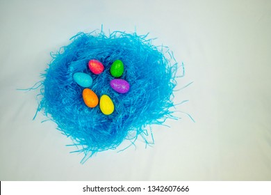 Colored decorative eggs on blue hay. Decorations for Easter. Brooklyn, NY , USA , February 10, 2019. 