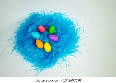 Colored decorative eggs on blue hay. Decorations for Easter. Brooklyn, NY , USA , February 10, 2019. 
