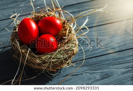 colored deep red Easter eggs in nest top view background, selective focus image. Happy Easter card	
