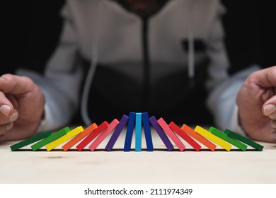 Colored Dominoes That Have Fallen Over From Both Sides And The Middle One Is Still Standing And Carrying All The Pressure. 