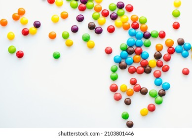 Colored dragee on a white background. Bright background. Round sweets. 