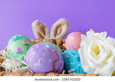 Colored Easter eggs and funny bunny in purple background .Copy sapce.Wallpaper for Easter announcements and cards.Horizontal real picture.
