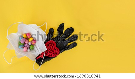 Colored easter eggs with medical face mask and red heart. COVID 19 easter greeting card, concept for easter holiday due to coronavirus epidemic quarantine. Stay Home. Be safe Easter