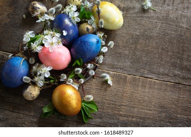 Colored Easter eggs in a nest with willow branches and spring flowers on a gray wooden background. Top view flat lay background. Copy space. - Shutterstock ID 1618489327