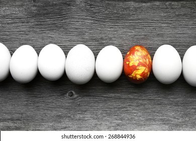 colored easter eggs on vintage country board with one standing out from the crowd