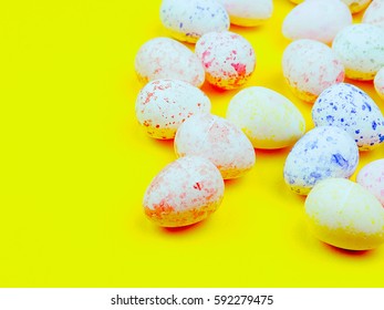 colored eggs for Easter on a bright yellow background, space for text, sun