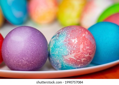 Colored eggs for Easter on a plate . White bottom of the plate. Blurred background.