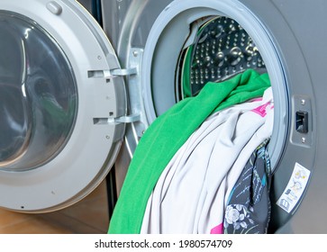 Colored fabrics in the washing machine prepare for washing. - Shutterstock ID 1980574709