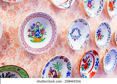 Colored With Flower Design, Ornamental Plate Is Hanging On The Wall.