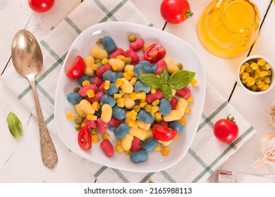 Colored gnocchi with vegetables and sweet corn.