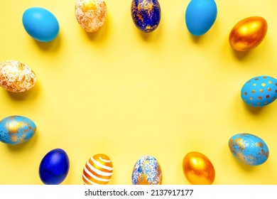colored golden, blue, light blue Easter eggs on a yellow background for Easter
