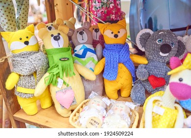 Colored handmade toys cats and teddy bears, yellow, brown, orange, in a green, blue and gray scarf. Russian text: handmade