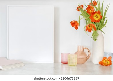 Colored Jug And Transparent Glasses With Water. Tulips In Vase, Book And Frame On Table. Stylish Kitchen Tableware And Flowers. Minimalism Style. Home Comfort. Objects Composition Idea