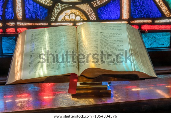 Stock photo of bible illustrated by stained glass windows