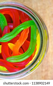 Colored Lolly Snakes In Jar On Wood 