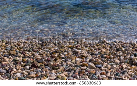 Colored pebbles on the sea beach.  Stones and sea background. 