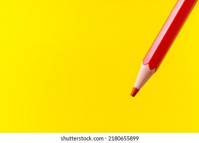 Colored pencil close-up with selective focus on the stylus and a blurred yellow background. Copy space for text.
