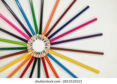 colored pencils are arranged in a circular pattern on a white surface