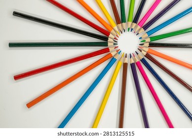 colored pencils are arranged in a circular pattern on a white surface