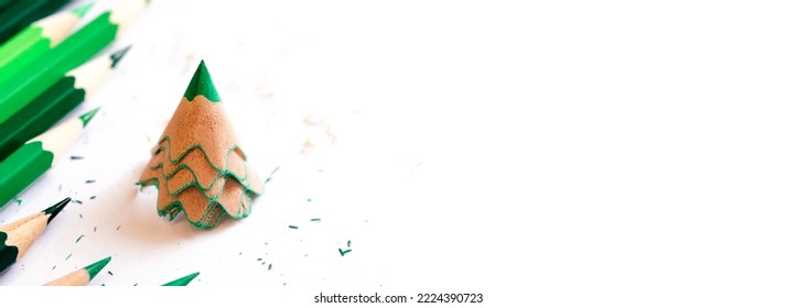 Colored pencils   creative Christmas tree made shavings from green pencil Christmas   New Year flat lay white background Copy space for text 
