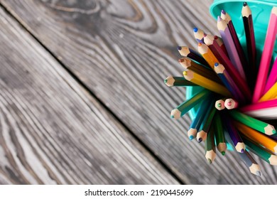 Colored Pencils For Drawing.  They Stand In A Pencil Holder In The Form Of A Trash Can. On Pine Boards.  Top View Close-up.