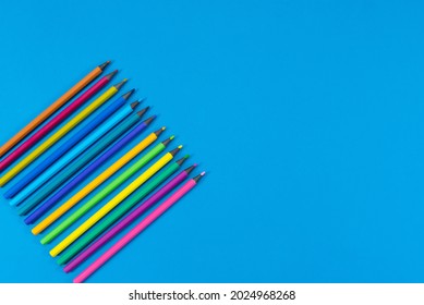 Colored pencils on a blue background. Back to school.